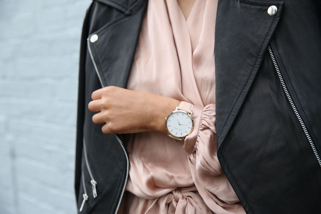 Close-up image of a woman wearing a black jacket, a pink blouse, and a watch - Ten powerful advertising techniques to lure customers and boost your sales - Image