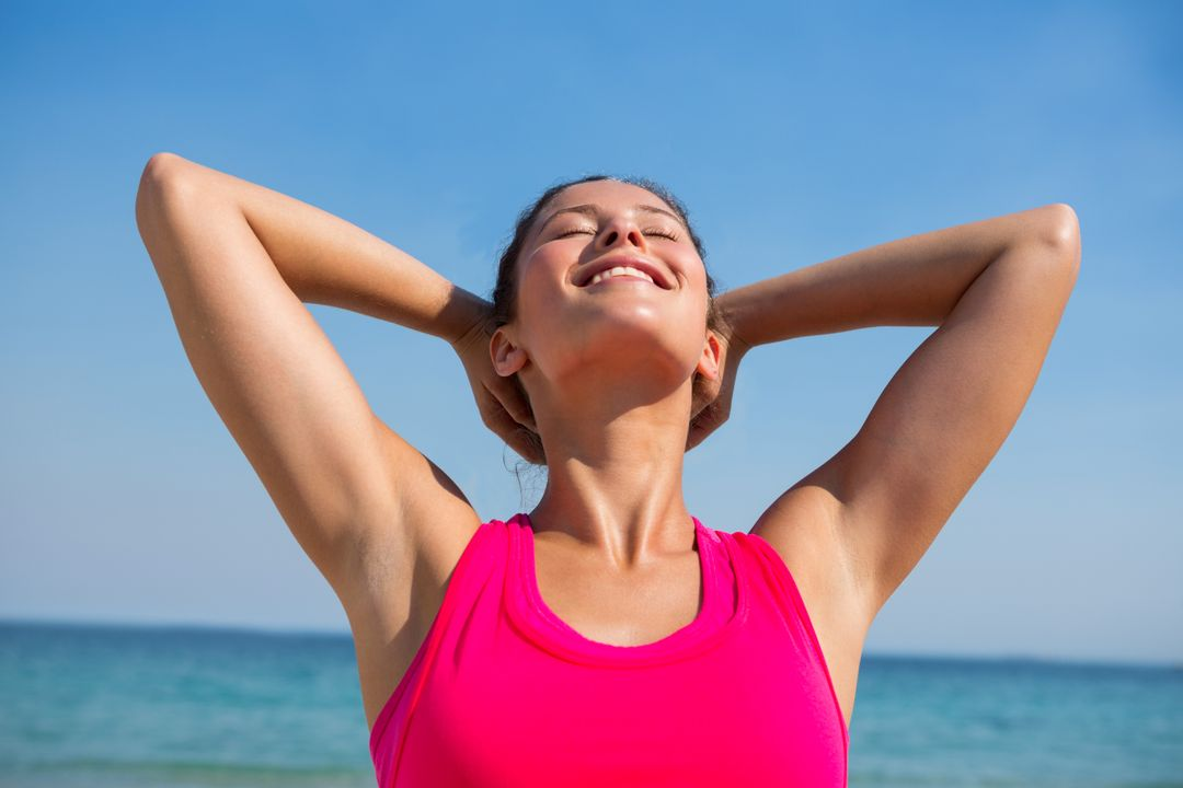 Image of a woman wearing a pink sports bra smiling at the beach - Ten powerful advertising techniques to lure customers and boost your sales - Image