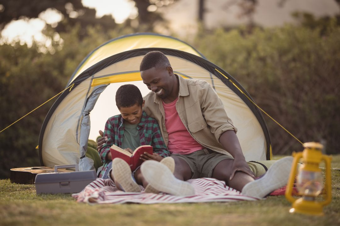 Image of a father and son reading a book together in front of a tent - Ten powerful advertising techniques to lure customers and boost your sales - Image
