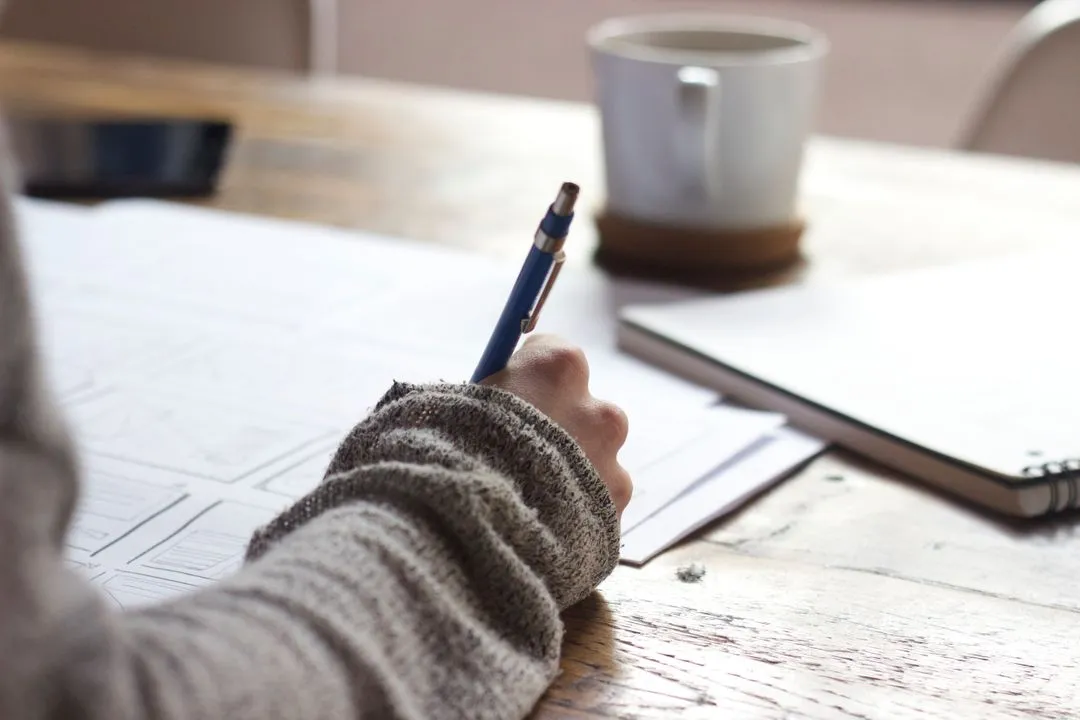 Image of a woman holding a pencil and taking notes - Topics and ideas for blogs that will inspire you and keep your readers engaged - Image