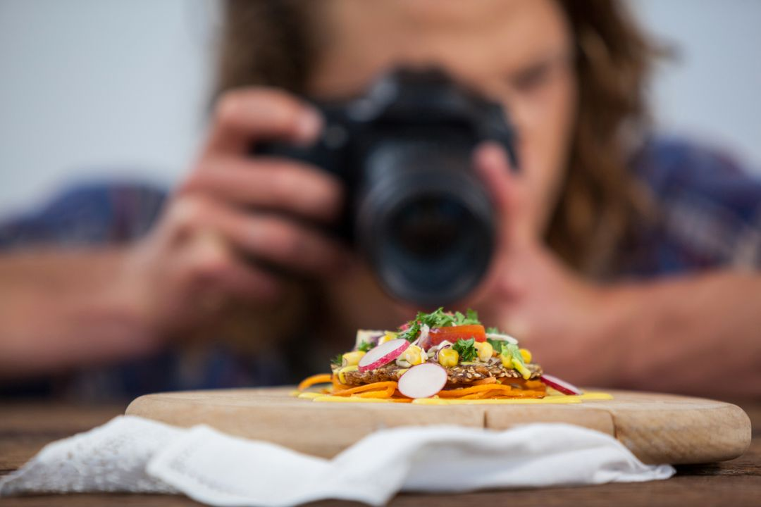 Image of a man taking a picture with a camera of a plate in the foreground - The beginner's guide to YouTube marketing, how to increase subscribers quickly - Image