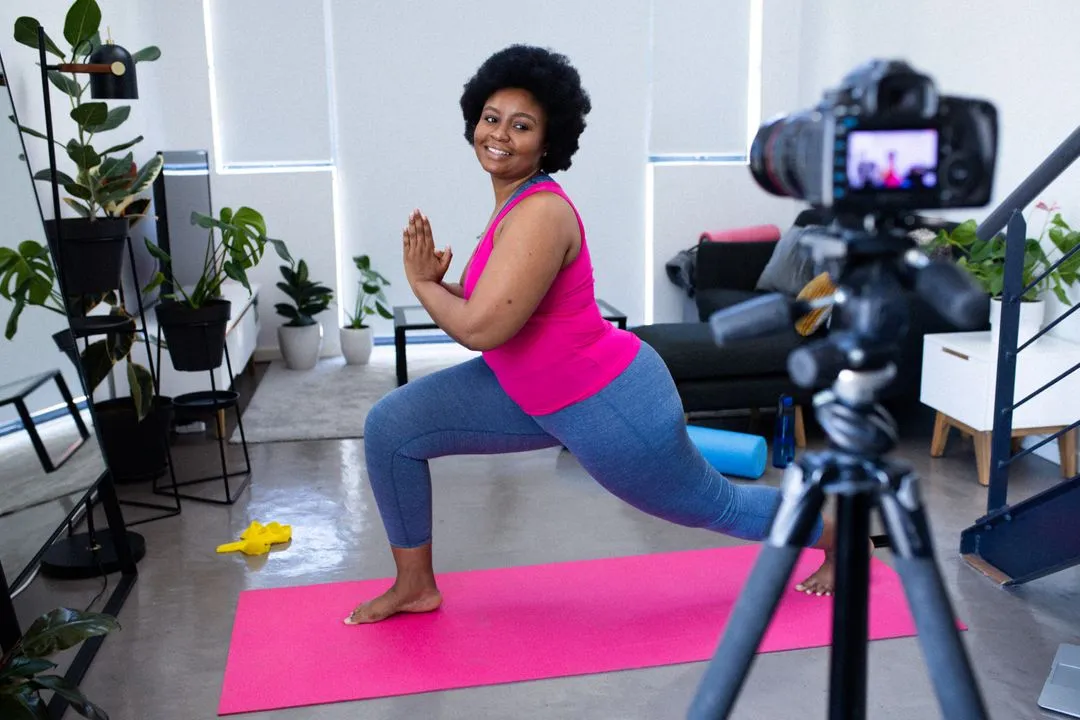 Image of a woman recording herself with a camera on a tripod doing yoga - The beginner's guide to YouTube marketing, how to increase subscribers quickly - Image