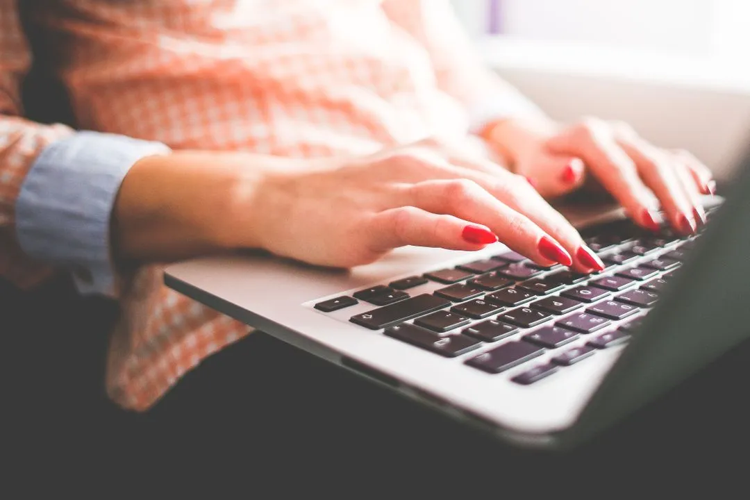 Image of woman with red painted nails using her laptop - 25 useful social media marketing ideas for boosting engagement - Image