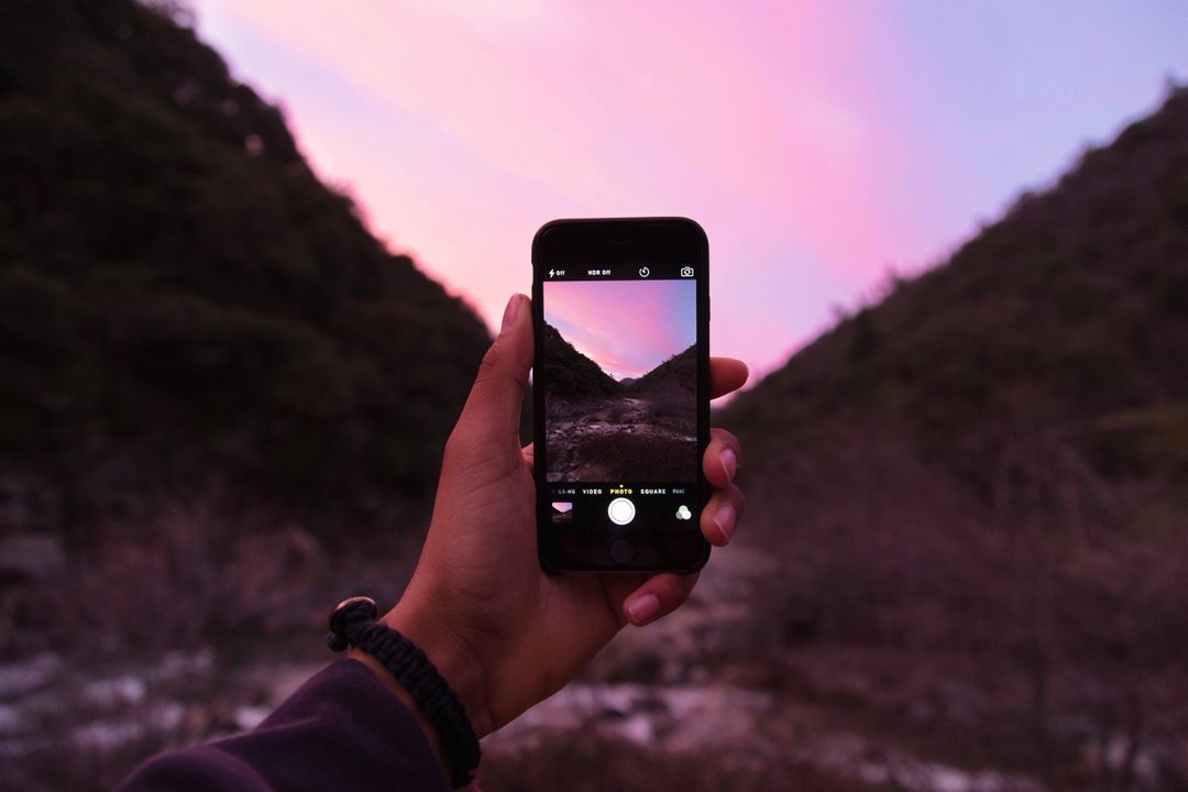 Image of a smartphone taking a picture at sunset - 25 useful social media marketing ideas for boosting engagement - Image