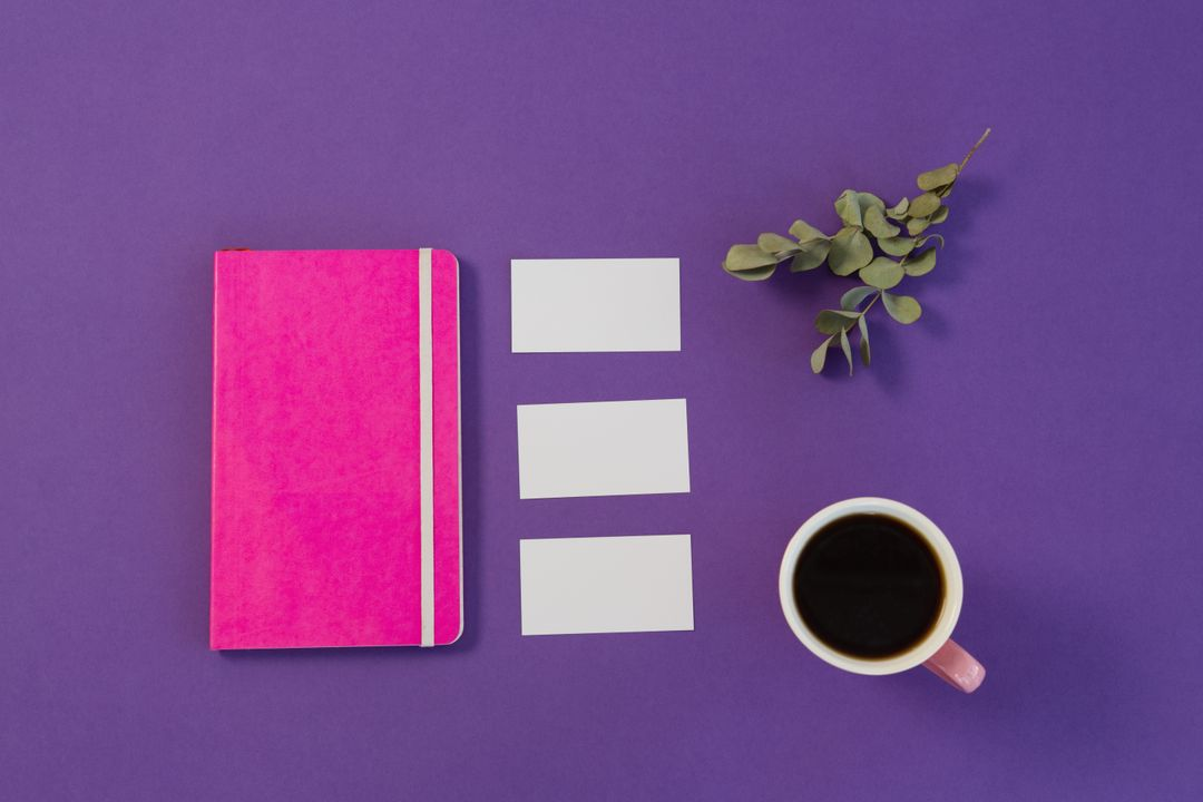 Image of a pink notebook and coffee on a purple background - 25 useful social media marketing ideas for boosting engagement - Image