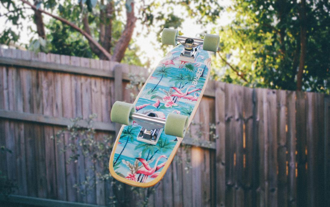 Image of a skateboard in the air in the foreground and a wooden fence and trees in the background - How to design a good business website: 18 key principles - Image