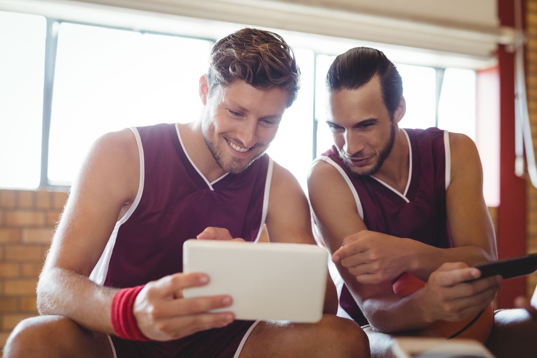 Basketball players talking while using digital tablet - Free Images, Stock Photos and Pictures on Pikwizard.com