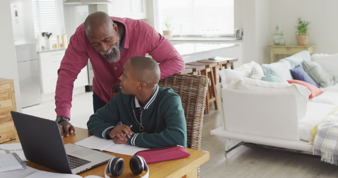 Image of happy african american father and son doing homework together - Free Images, Stock Photos and Pictures on Pikwizard.com