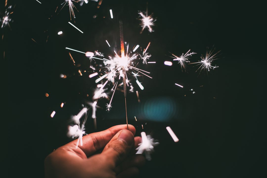 A man holds a festive sparkler in his hand - A selection of images from the PikWizard team on the eve of the New Year - Image