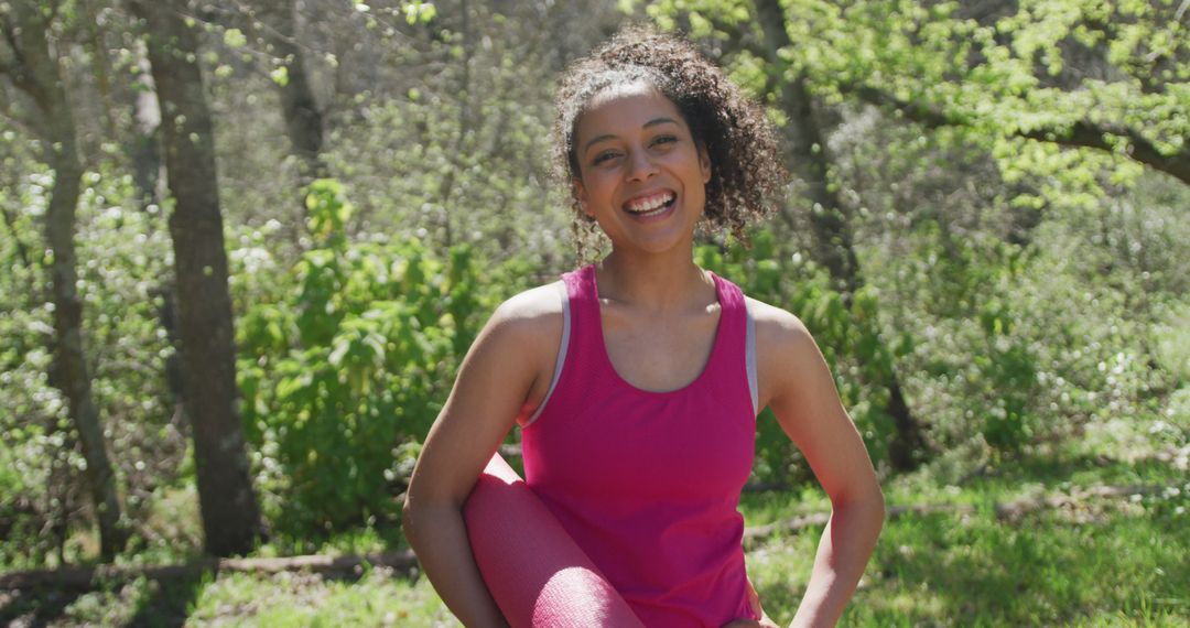 Portrait of smiling biracial woman wearing sportswear in forest with yoga mat - Free Images, Stock Photos and Pictures on Pikwizard.com