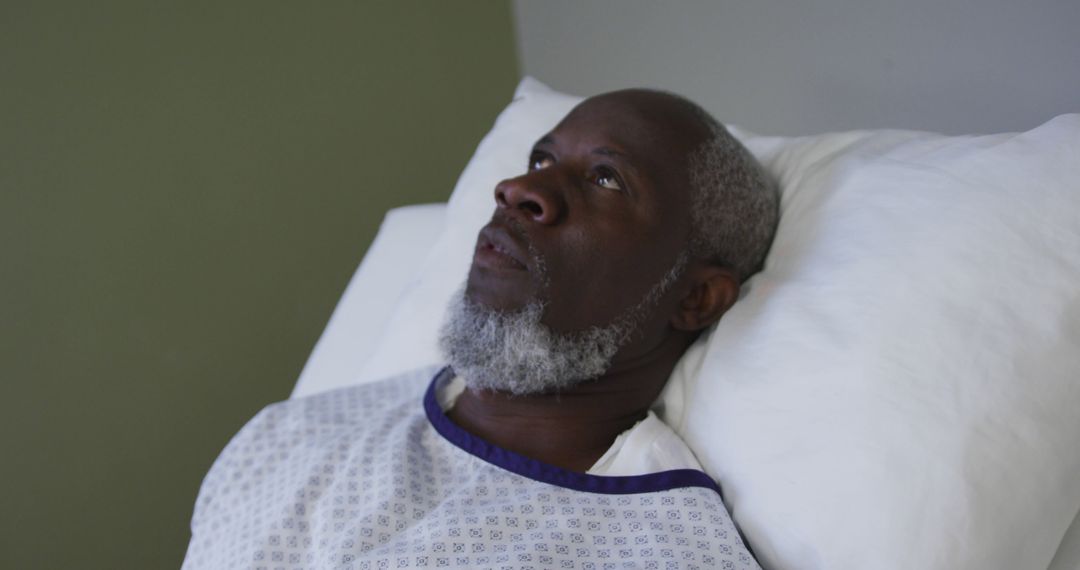 African american male patient lying in hospital bed and yawning - Free Images, Stock Photos and Pictures on Pikwizard.com