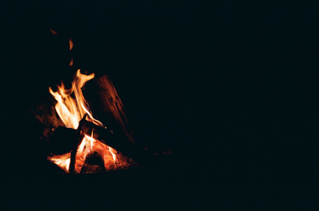 Small burning pile of wood with black background