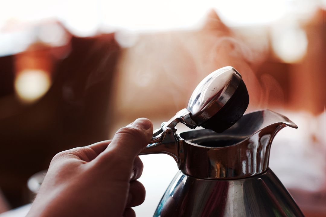 a person pouring coffee into a coffee pot - Free Images, Stock Photos and Pictures on Pikwizard.com