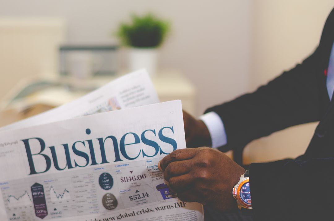 Image of a man holding a business newspaper - A practical guide on how to get the most out of your writing if you're planning on starting a money blog - Image