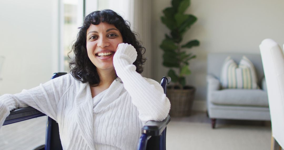 Portrait of happy biracial disabled woman in wheelchair laughing in living room - Free Images, Stock Photos and Pictures on Pikwizard.com