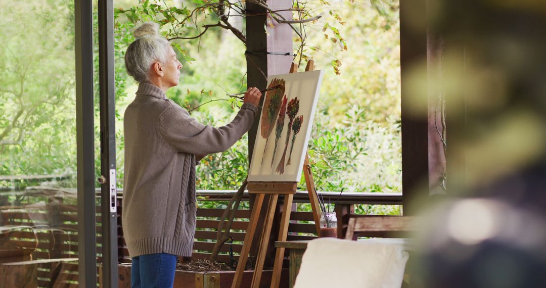 Woman painting at an easel in a garden