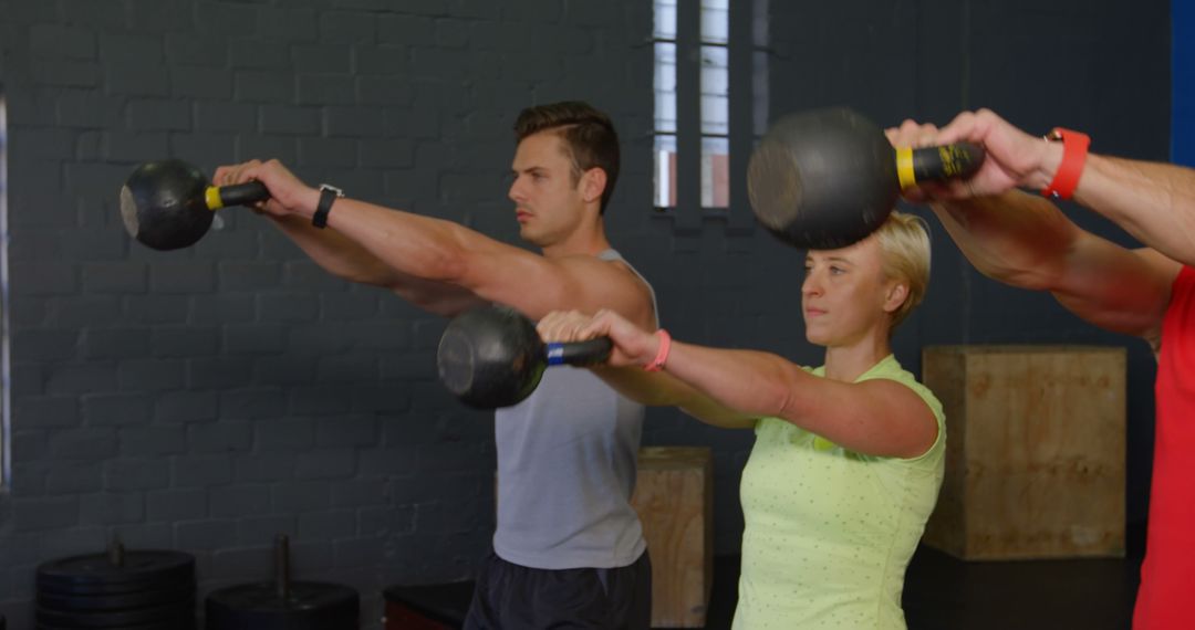 Group of people exercise with kettlebell in gym from Pikwizard