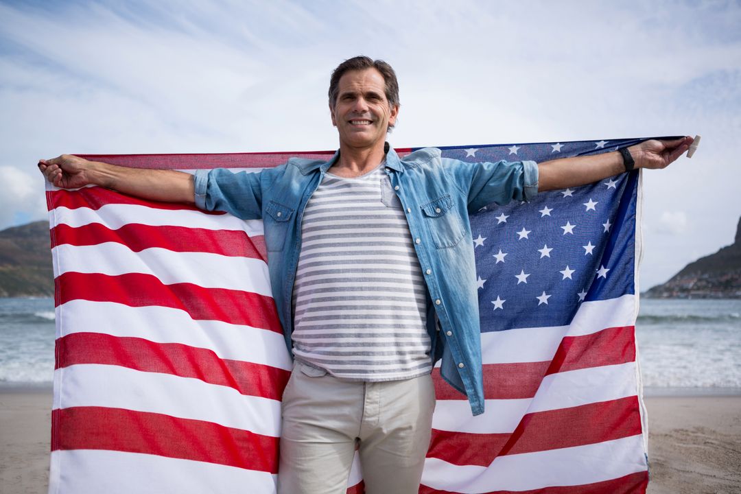 Man holding american flag on beach - Free Images, Stock Photos and Pictures on Pikwizard.com