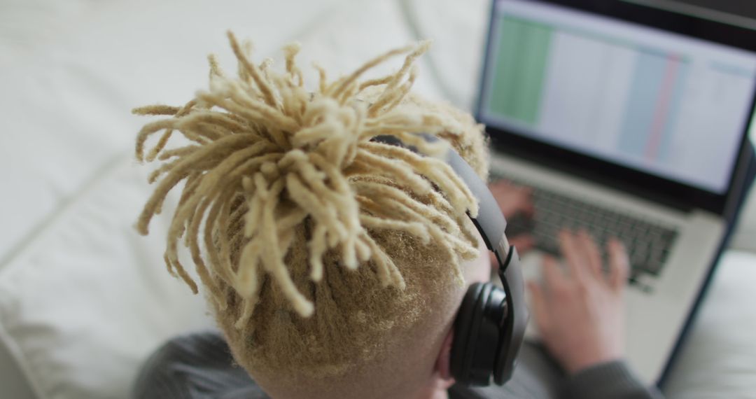 Albino african american man with dreadlocks using tablet and headphones - Free Images, Stock Photos and Pictures on Pikwizard.com
