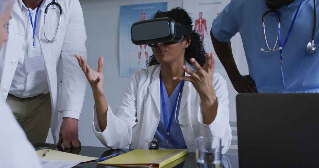 Asian female doctor at table using vr headset with a diverse group of colleagues gathered around her - Free Images, Stock Photos and Pictures on Pikwizard.com