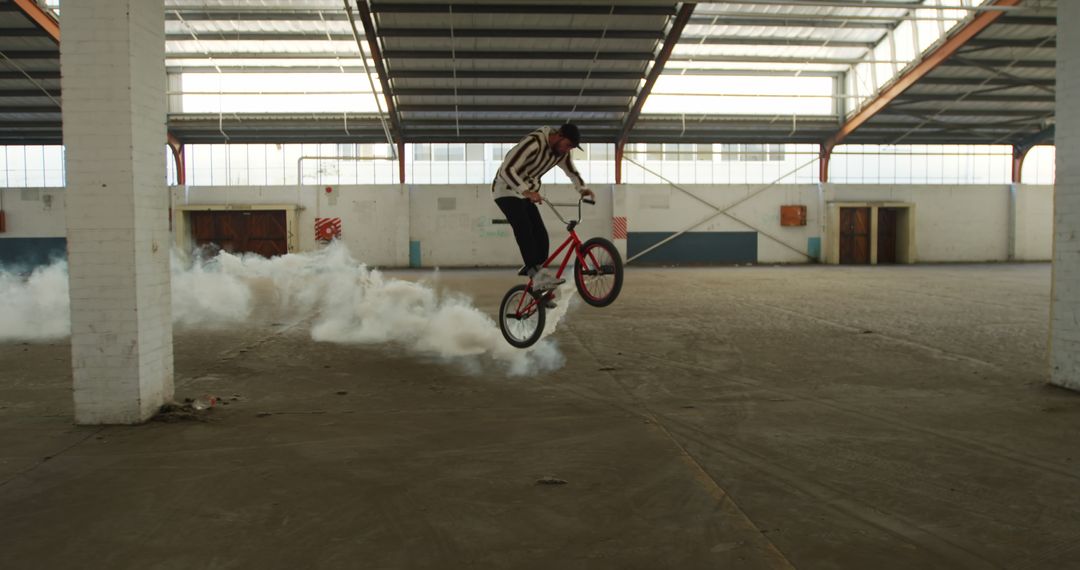 Caucasian man riding bmx bike jumping with white smoke bomb