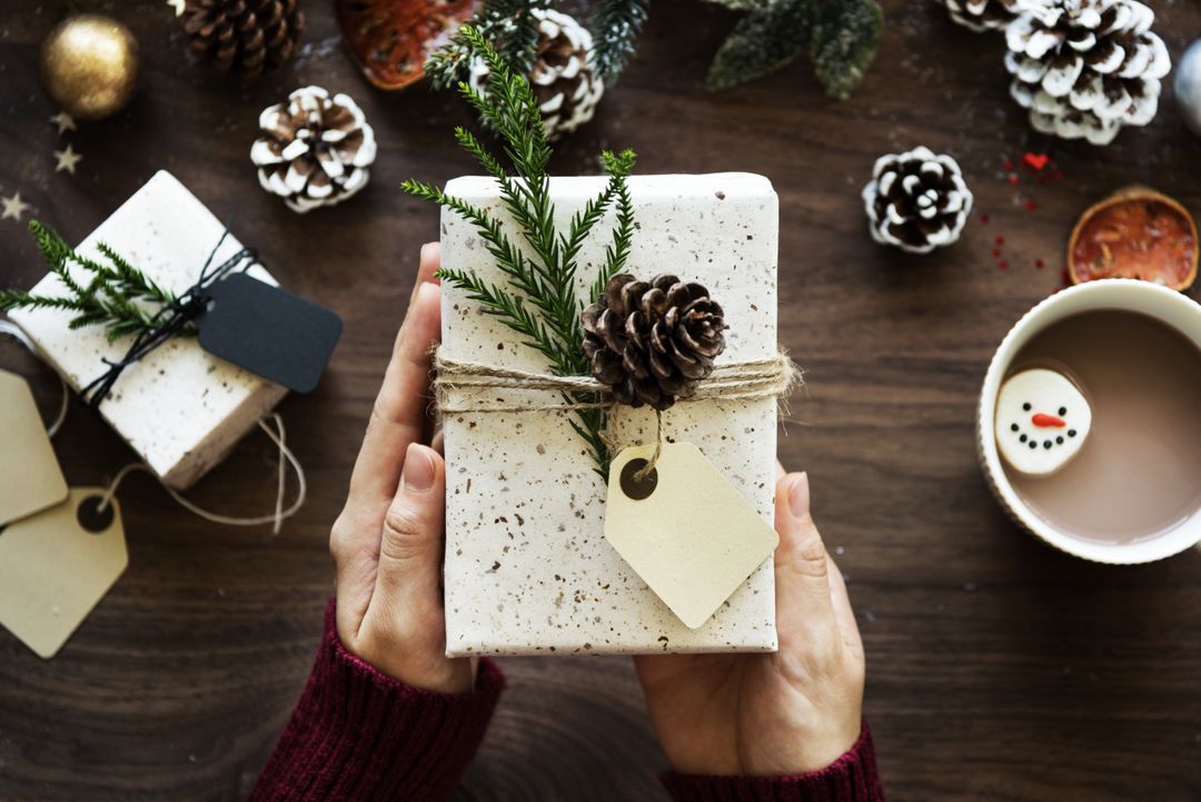 Image of a person holding a wrapped present in his hands - A selection of interesting Christmas images from the PikWizard team - Image