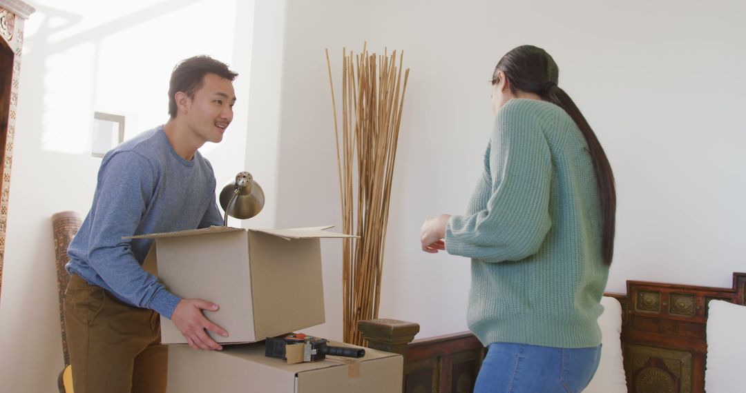 Image of happy diverse couple unpacking boxes after moving in - Free Images, Stock Photos and Pictures on Pikwizard.com