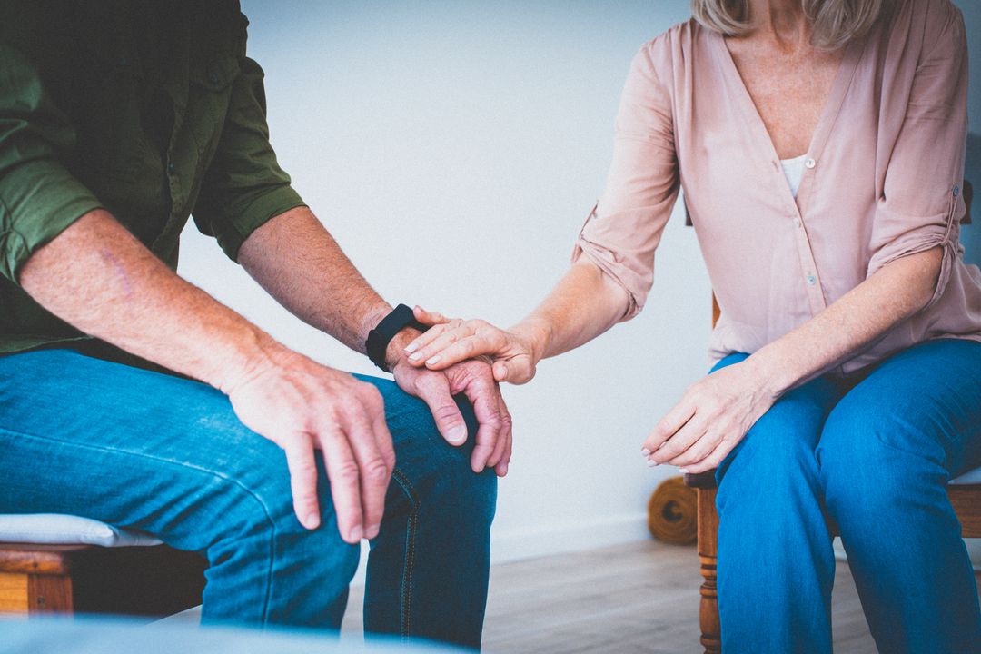 Couple sitting close with hands together 
