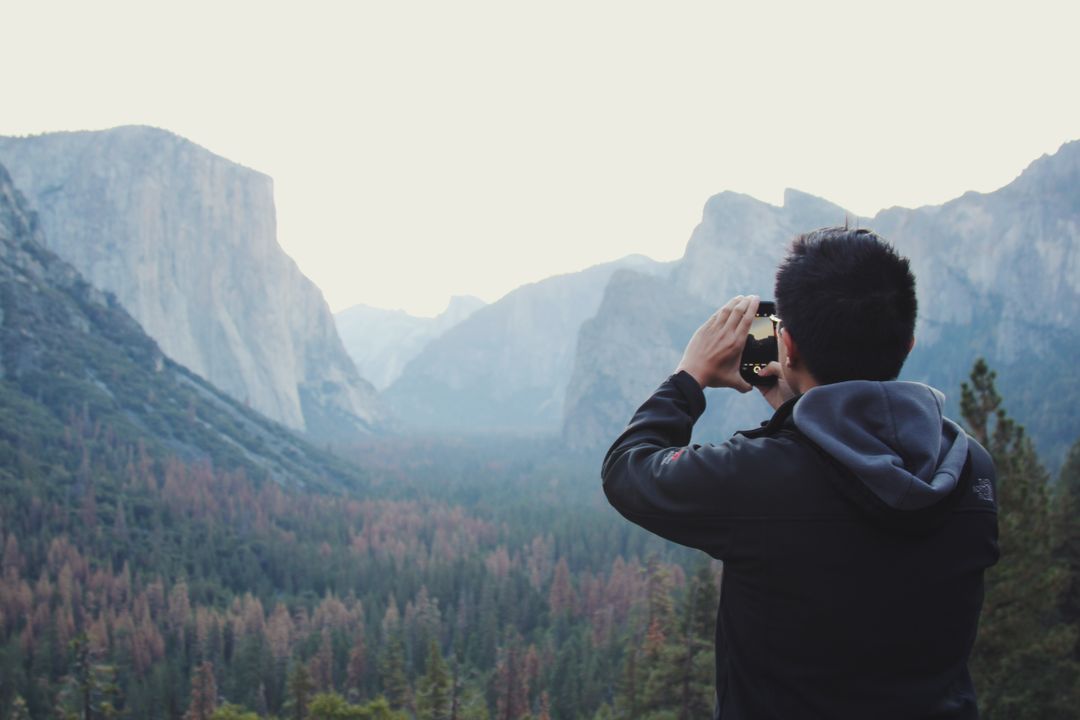 Image of a Man Taking a Photograph of the Landscape with his Mobile Phone