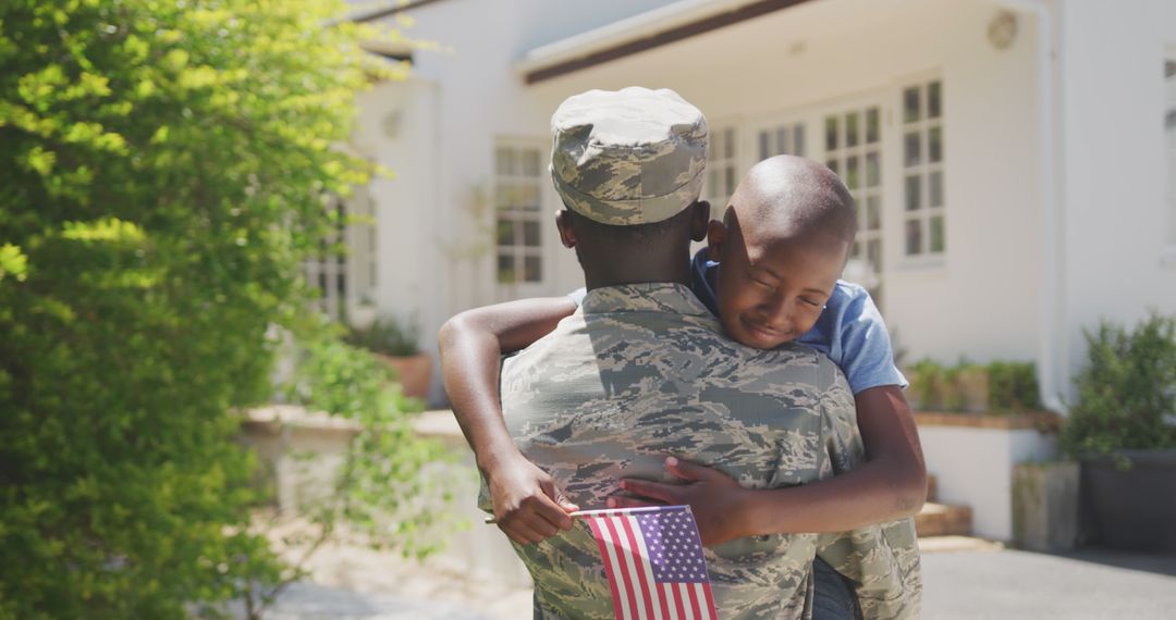 Happy african american male soldier and his son embracing outside the house - Free Images, Stock Photos and Pictures on Pikwizard.com