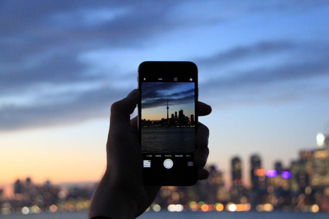 Image of a person taking a photo of a city on their iPhone 