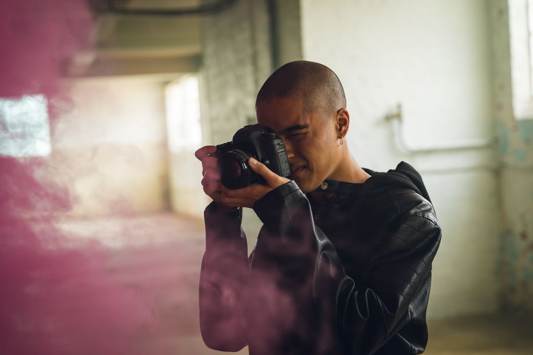Image of a person taking an image of pink smoke in a warehouse