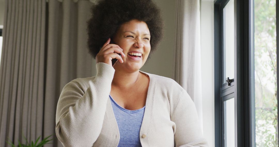 Image of happy plus size african american woman using smartphone