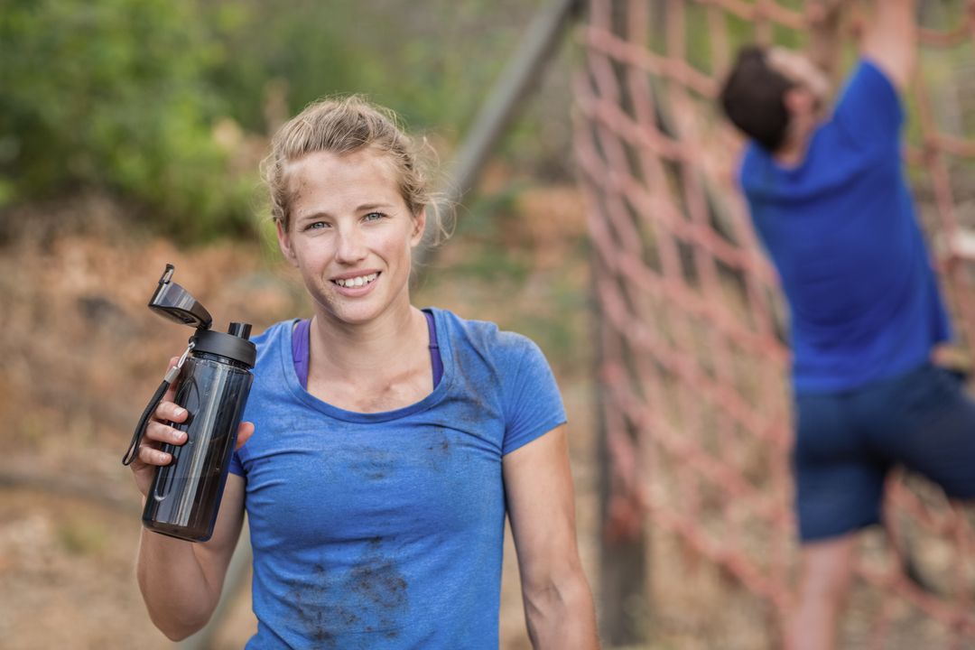 Portrait of woman holding water bottle during obstacle course - Free Images, Stock Photos and Pictures on Pikwizard.com