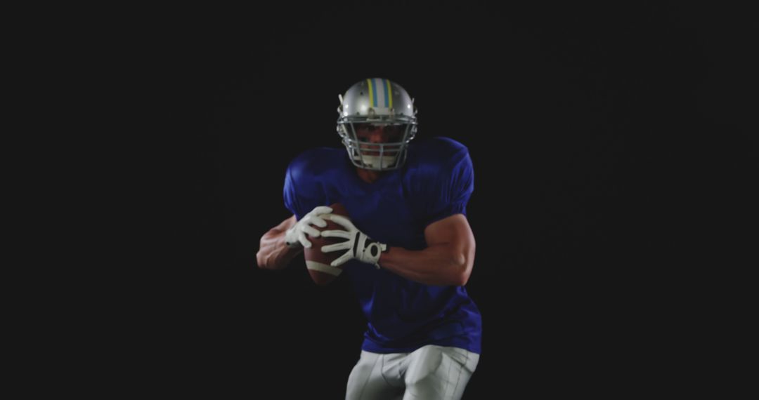 Football Player Holding Football With Both Hands Stock Photo