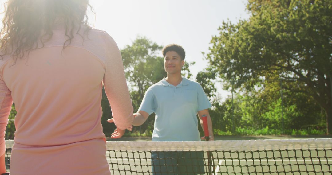 Image of happy biracial couple playing tennis on the court - Free Images, Stock Photos and Pictures on Pikwizard.com