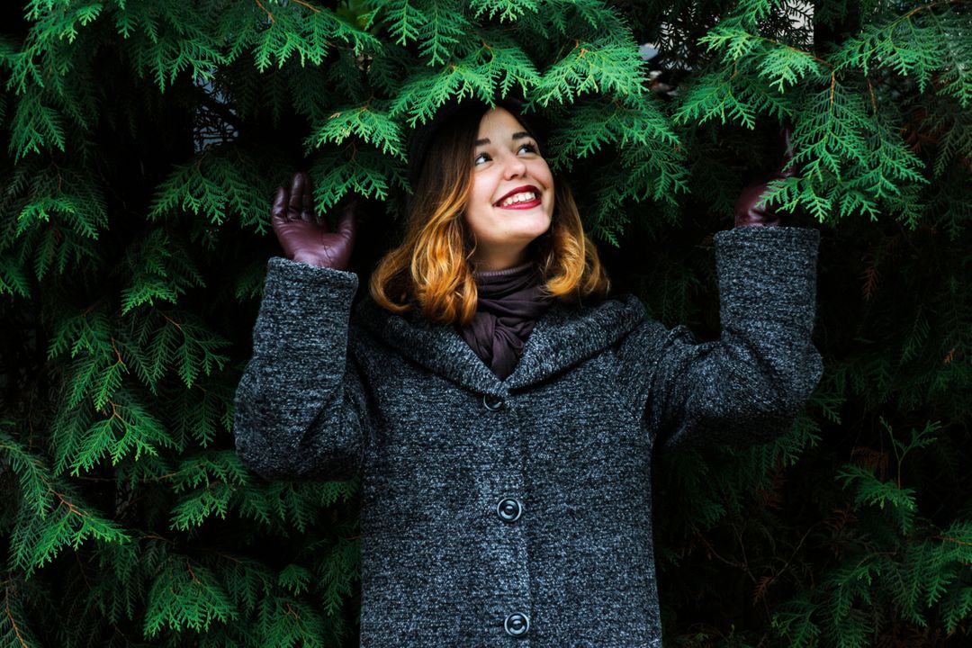 Woman standing under bush smiling