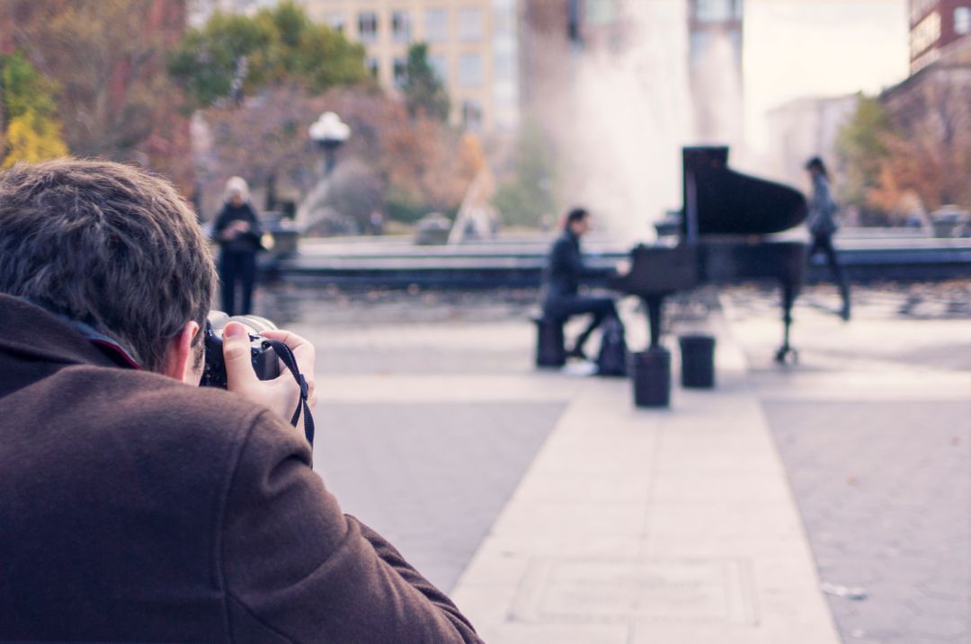 Image of a Man Taking a Picture of a Pianist with a Camera