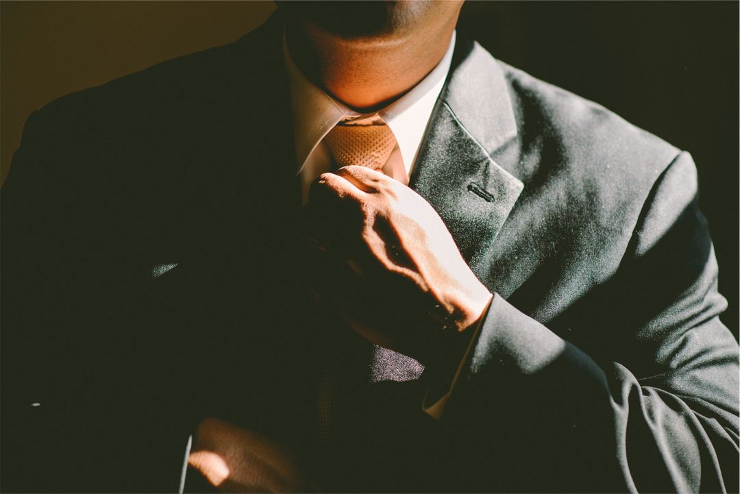 Photograph of a man adjusting his tie