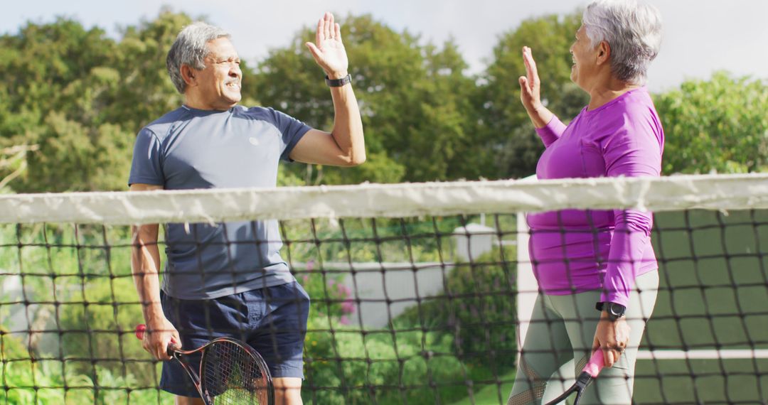 Image of happy biracial senior couple clapping hands during tennis training - Free Images, Stock Photos and Pictures on Pikwizard.com