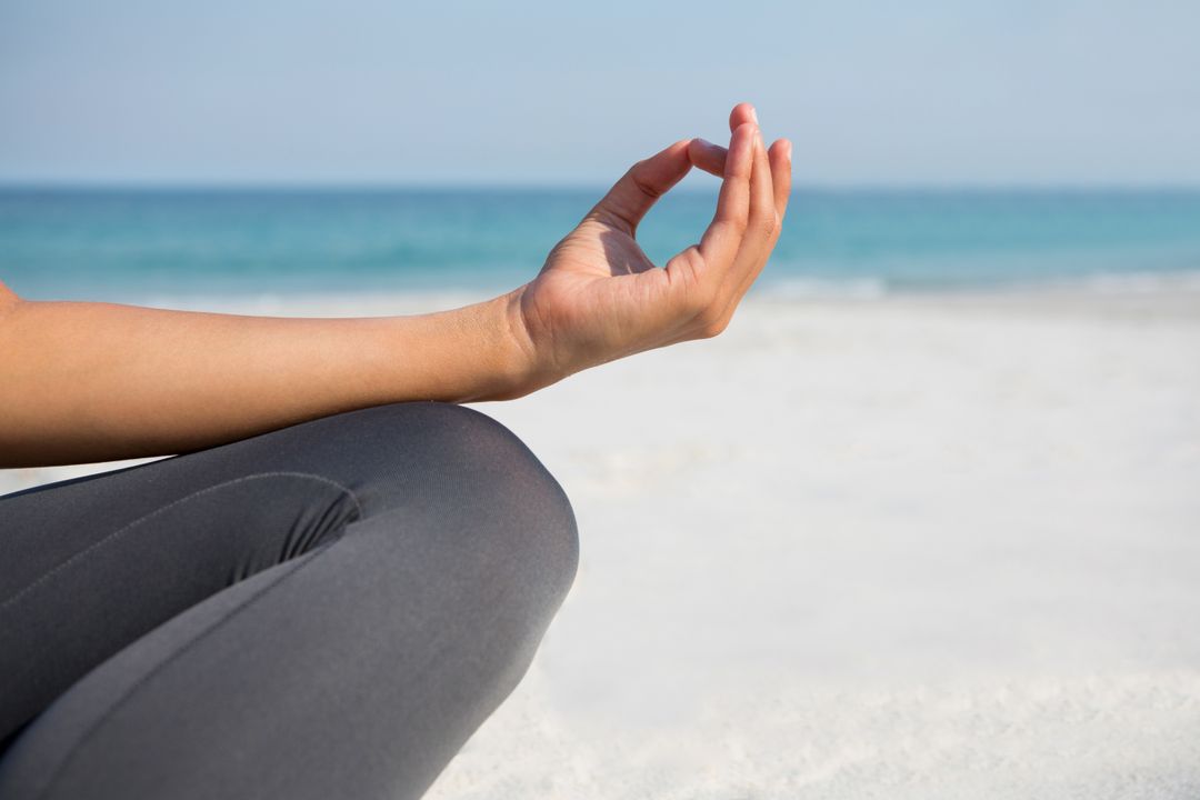 Cropped image of woman meditating at beach - Free Images, Stock Photos and Pictures on Pikwizard.com