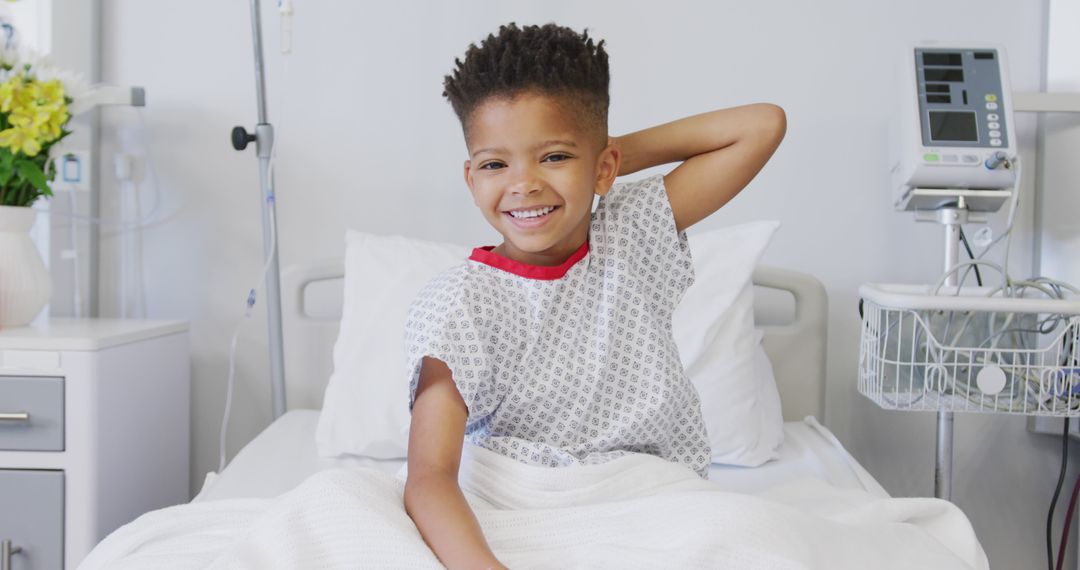 Portrait of happy african american boy patient sitting up in bed at hospital smiling - Free Images, Stock Photos and Pictures on Pikwizard.com