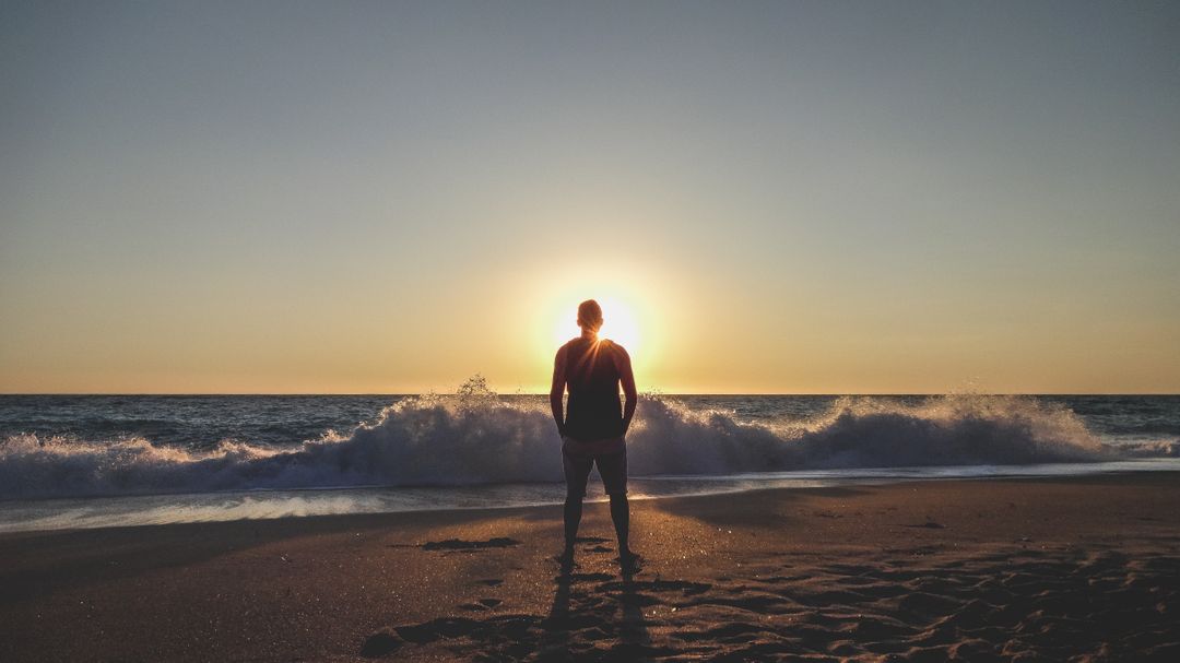 Man standing on a beach looking at the sunset - Essential steps to start a lifestyle blog and be successful - Image