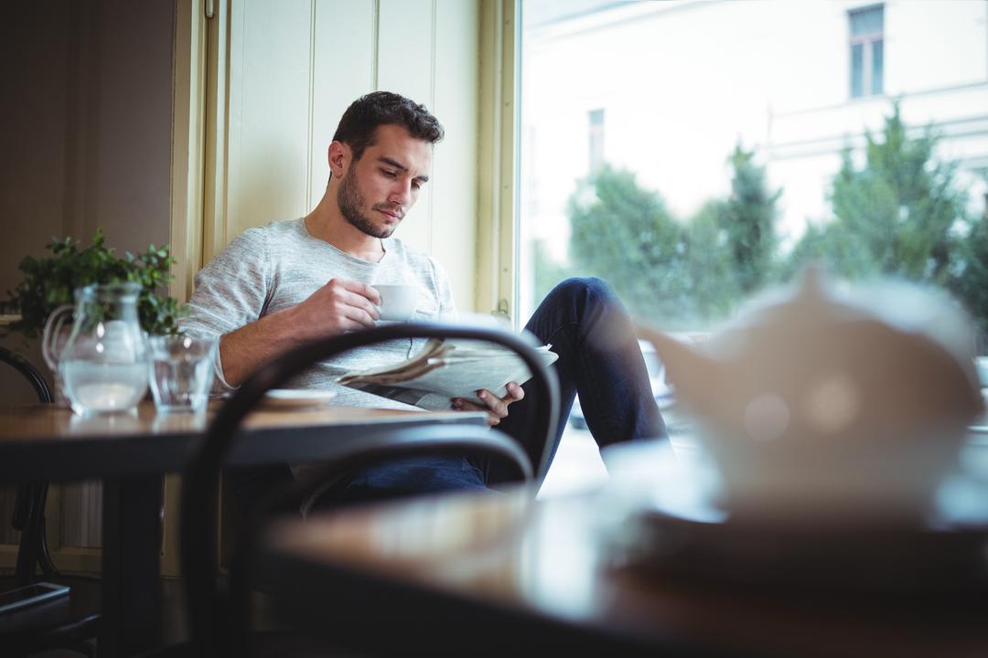 Image of a Man Reading the Newspaper and Drinking Coffee
