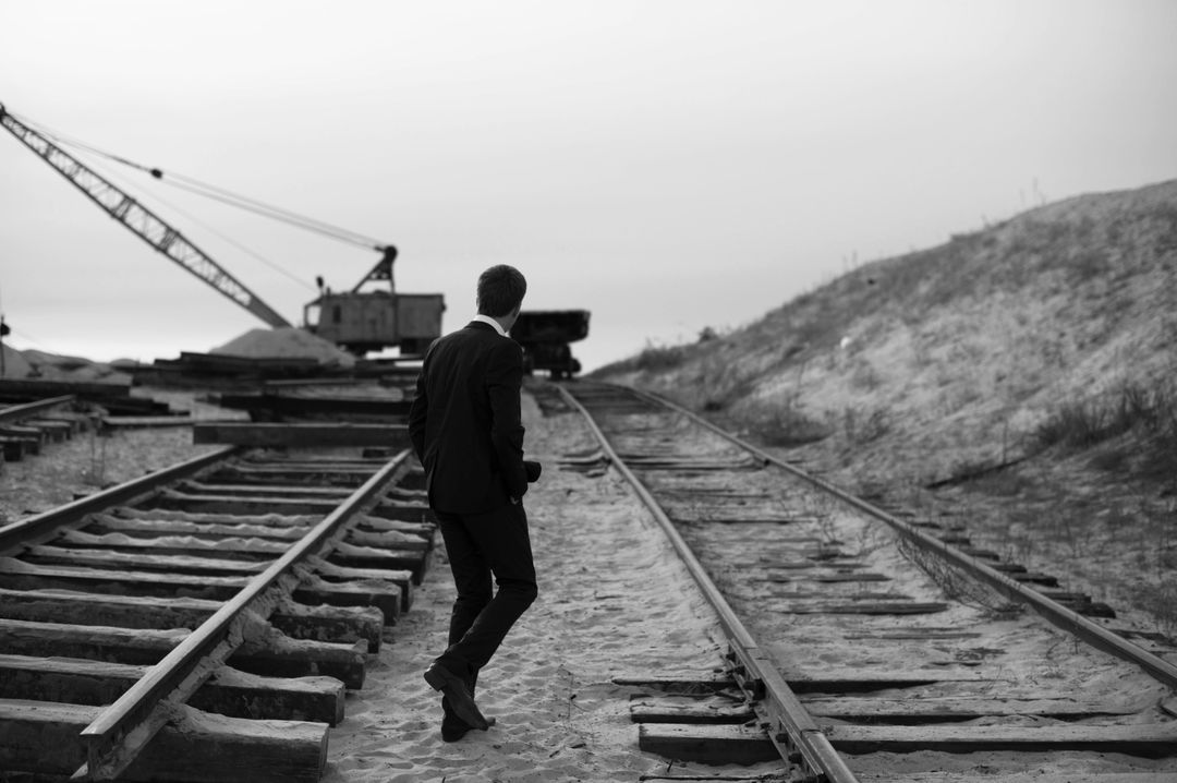 a man walking on railroad tracks - Free Images, Stock Photos and Pictures on Pikwizard.com