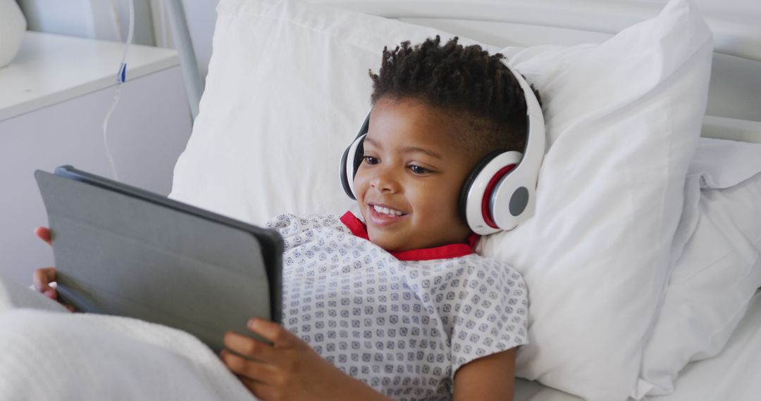 Happy african american boy patient using tablet and wearing