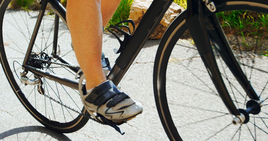 Close up of a cyclist s legs pedaling a road bike outdoors from