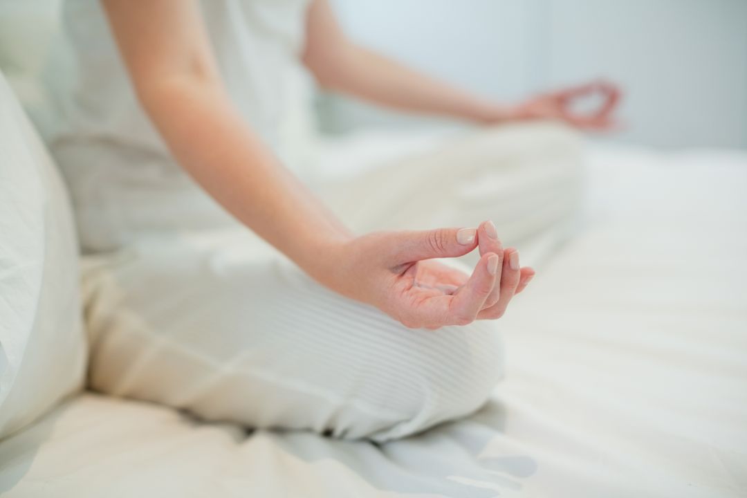 Woman doing meditation on her bed relaxing
