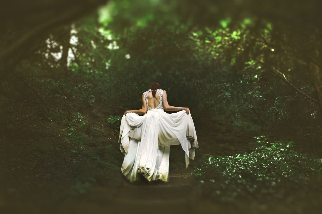 Woman Running through forest in wedding dress
