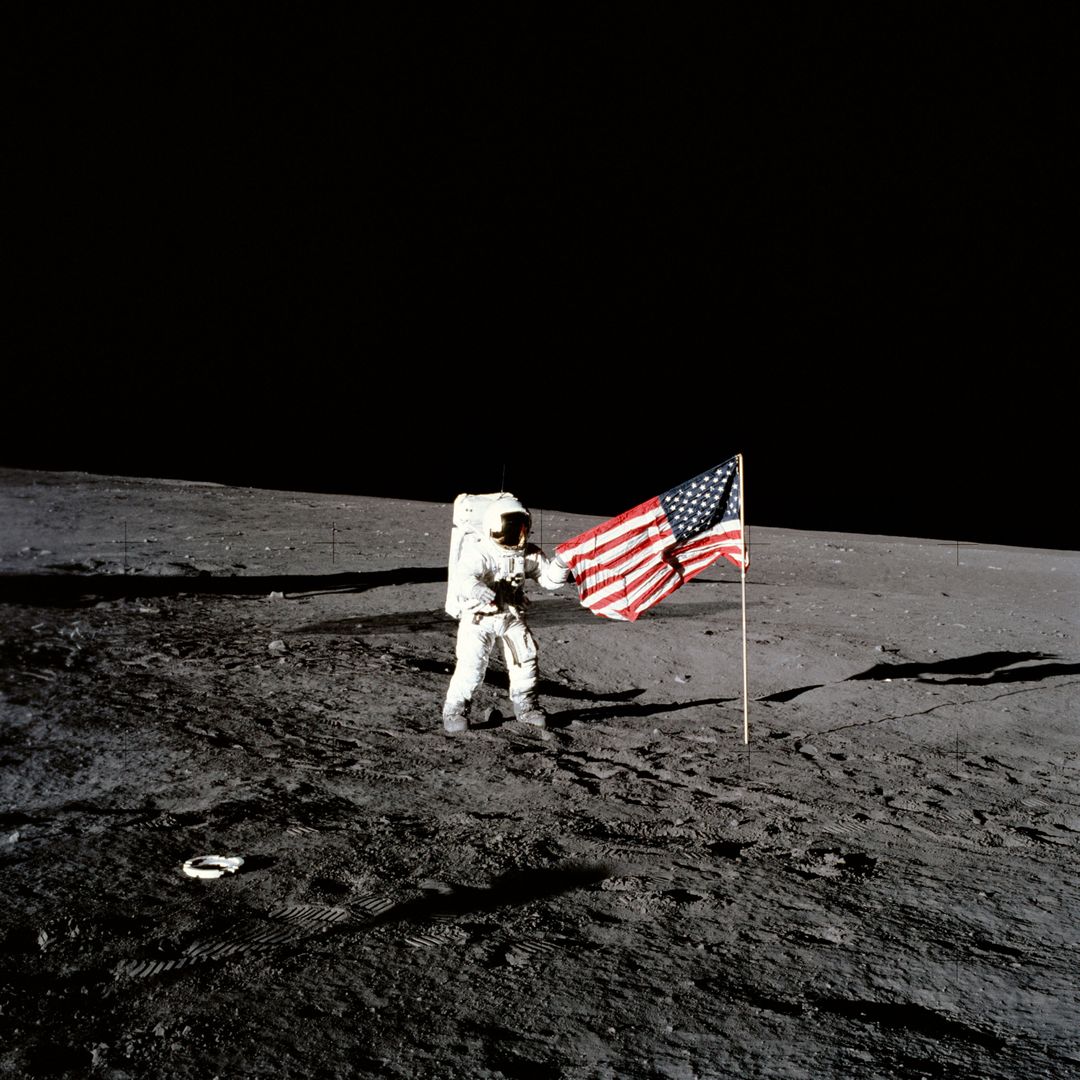 Apollo 12 astronaut stands beside United States flag after is was unfurled - Free Images, Stock Photos and Pictures on Pikwizard.com